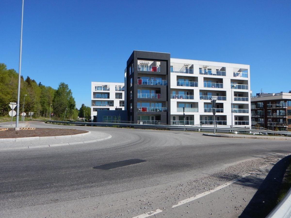 Hvitt leilighetsbygg ved en rundkjøring